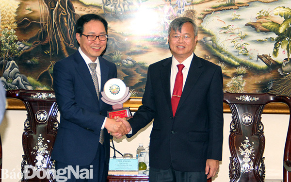 Phó bí thư Tỉnh ủy, Chủ tịch UBND tỉnh Cao Tiến Dũng tặng quà cho ông Choi Joo Ho, Tổng Giám đốc tổ hợp Samsung Việt Nam tại buổi tiếp đoàn Samsung Việt Nam đến chào xã giao lãnh đạo tỉnh