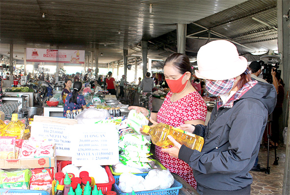 Người dân chọn mua các sản phẩm hàng Việt tại một sạp hàng ở chợ Bảo Hòa (H.Xuân Lộc)